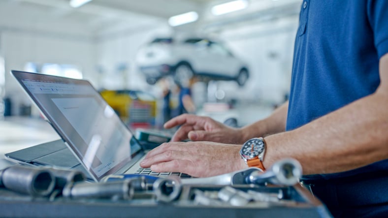 EHS-Man-typing-car-on-lift