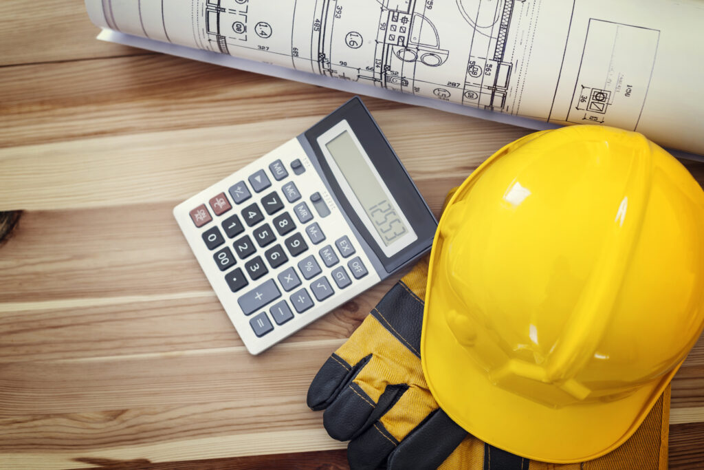calculator with construction worker hat, gloves, and blue print