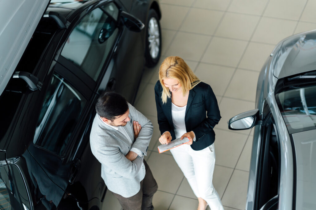 salesperson showing vehicle to customer