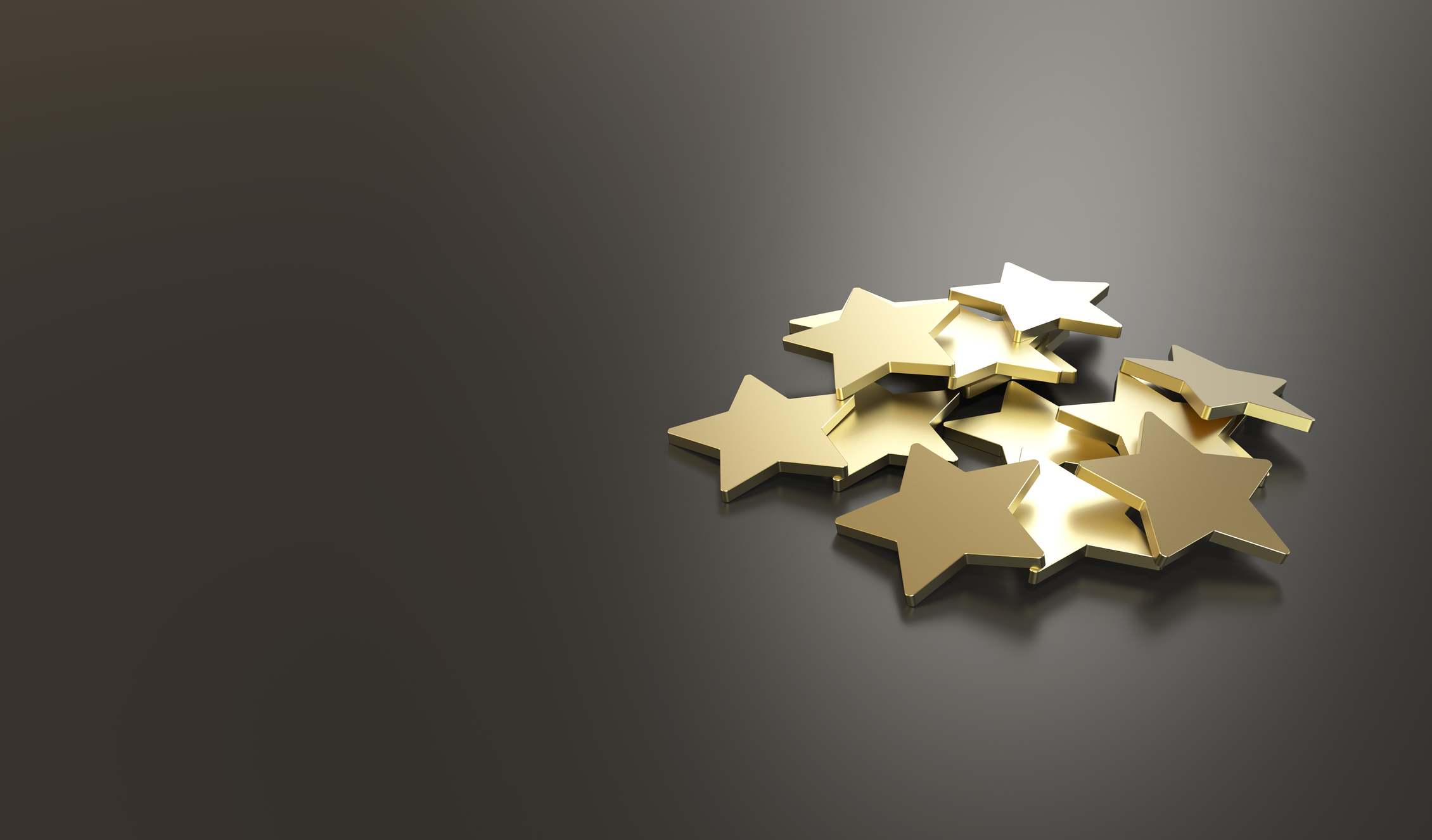 cutout gold stars piled on gray background