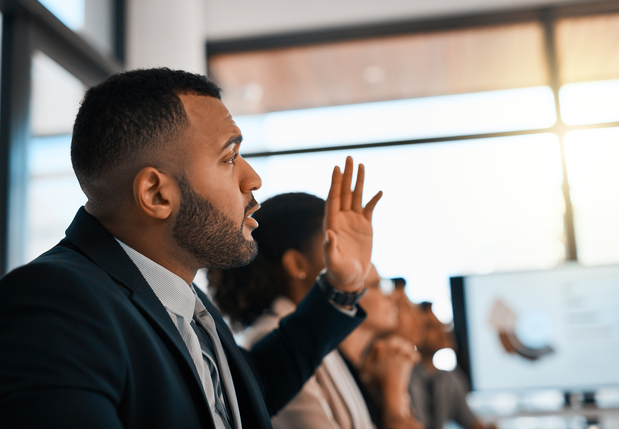 business person raising hand during meeting