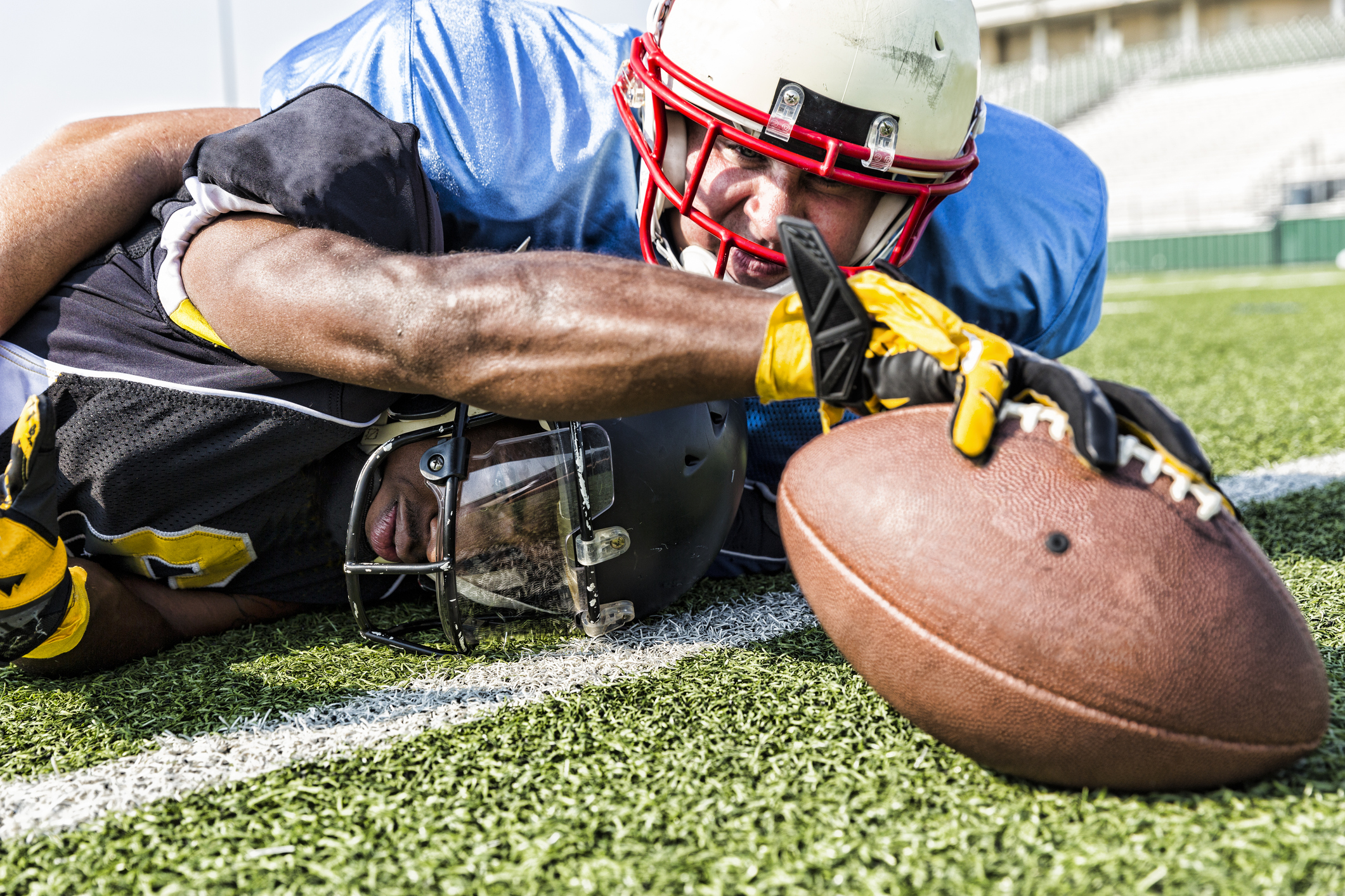 football player making a touchdown while tackled