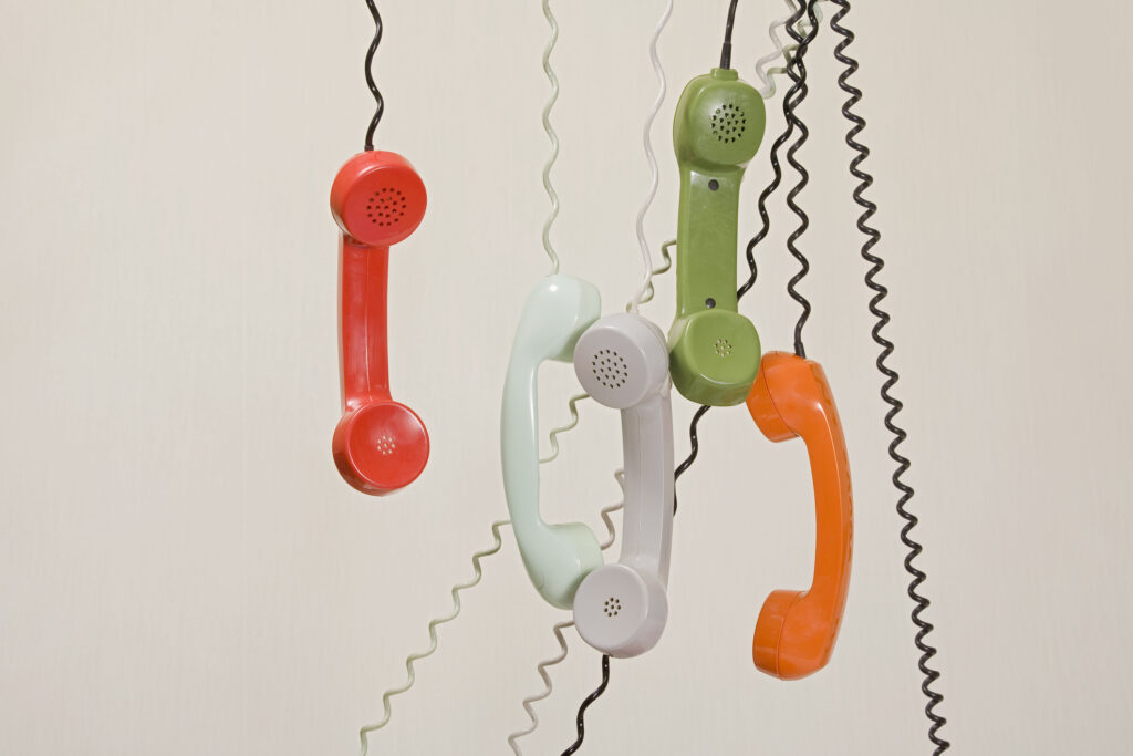 phone handsets hanging by chords
