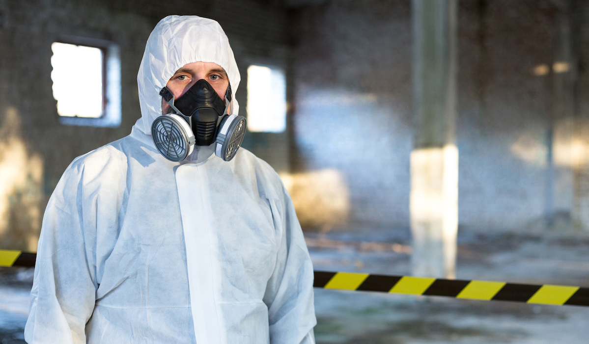 Emergency Respiratory Protection specialist stands inside the building where the accident occurred.